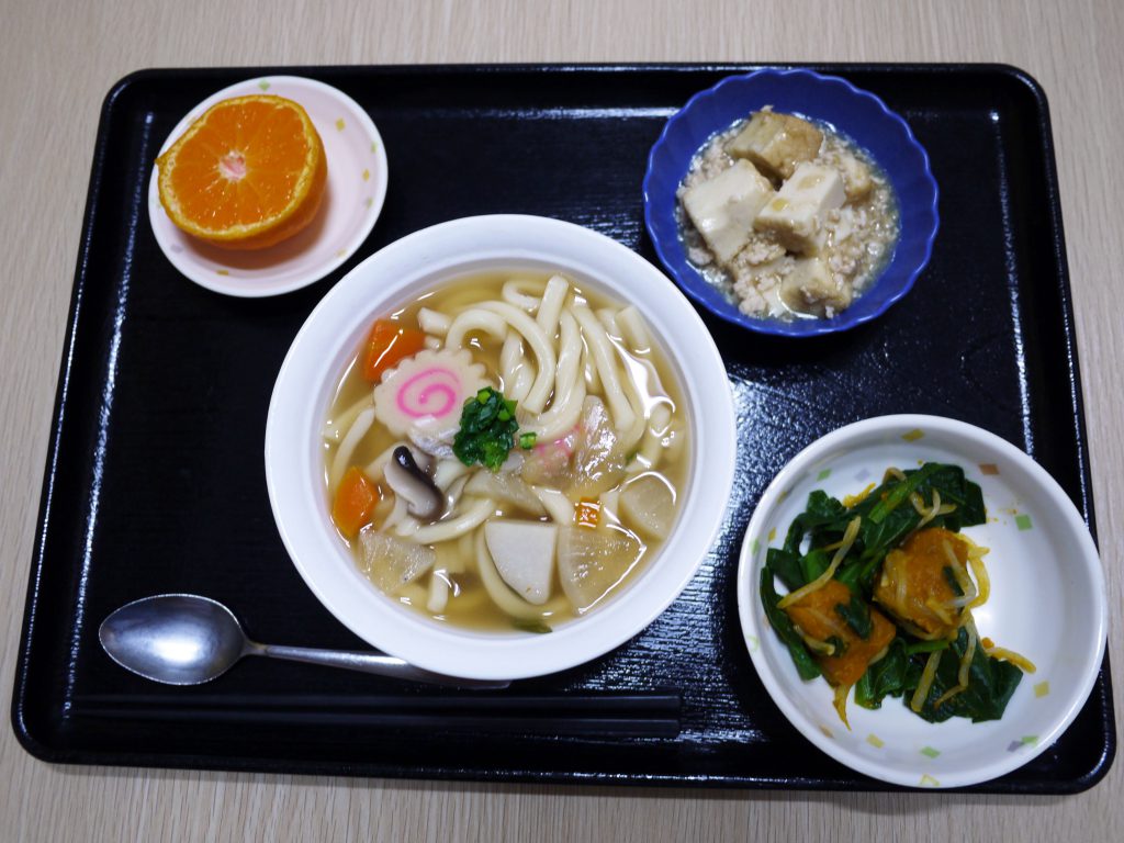 きょうのお昼ごはんは、煮込みうどん・そぼろ煮・青菜和え・くだものでした。