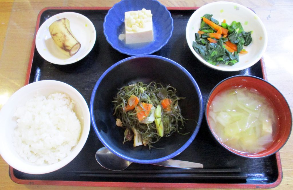 きょうのお昼ごはんは、豚肉と切り昆布の煮物・青菜のからし和え・煮奴・みそ汁・くだものでした。