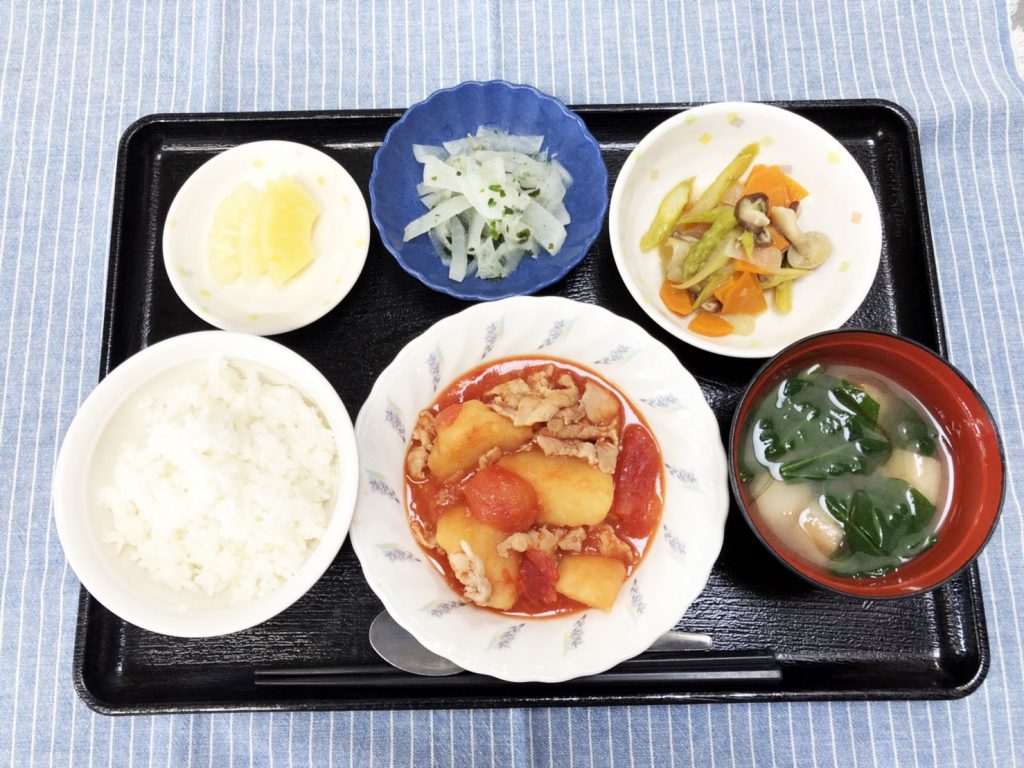 きょうのお昼ごはんは、豚肉とじゃが芋のトマト煮・アスパラガスの炒め物・浅漬け・みそ汁・くだものでした。