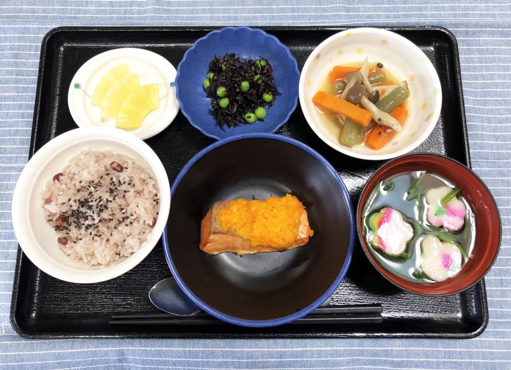 きょうのおひるごはんは、白寿お祝いお赤飯・焼き魚・炊き合わせ・ひじきの酢の物・お吸い物・くだものでした。きょうは、100歳をお迎えになる方の誕生会をみんなでお祝いします。