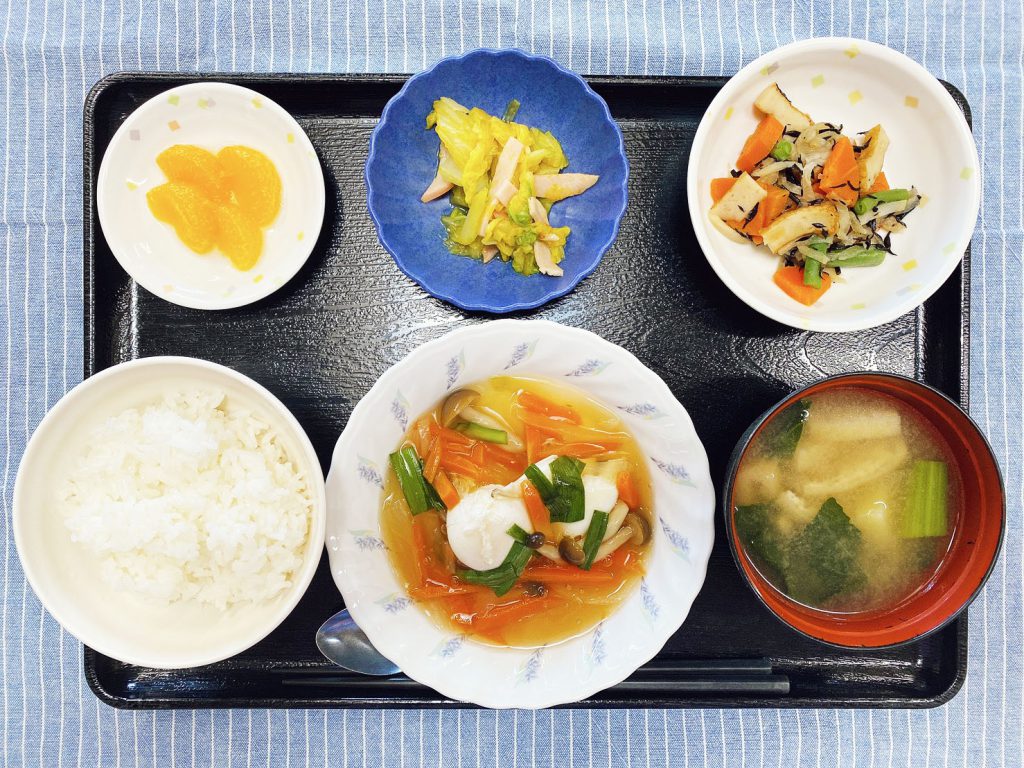 きょうのお昼ごはんは、落とし卵の野菜あんかけ・ハムと白菜カレー和え・煮物・みそ汁・くだものでした。