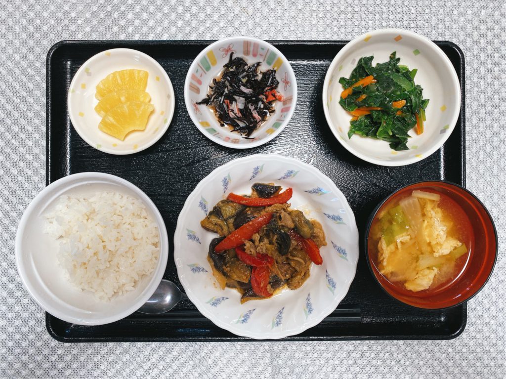 きょうのお昼ごはんは、ナスと豚肉の鍋しぎ・青菜和え・ひじきの酢の物・みそ汁・くだものでした。