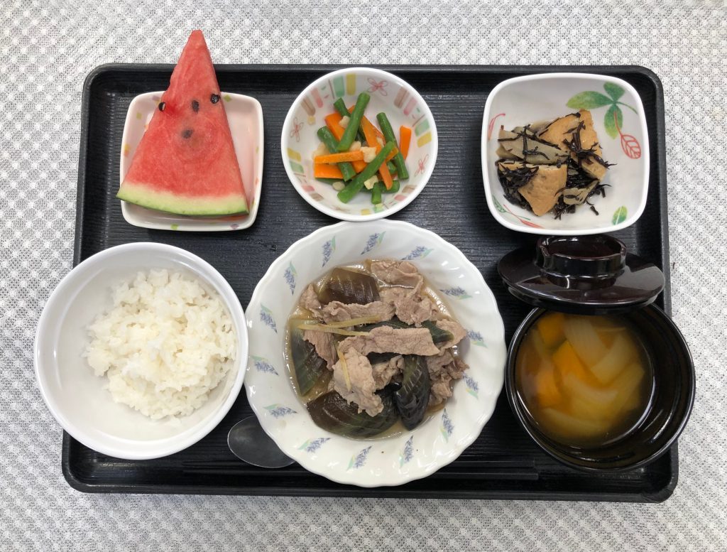 きょうのお昼ごはんは、なすと豚肉の生姜煮・いんげんと人参の天かす和え・炒め煮・みそ汁・くだものでした。