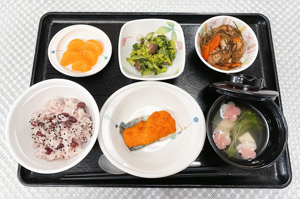 3月25日土曜日　きょうのお昼ごはんは、卒園お祝いお赤飯・鰆の人参マヨネーズ焼き・わさび和え・含め煮・お吸い物・くだものでした。