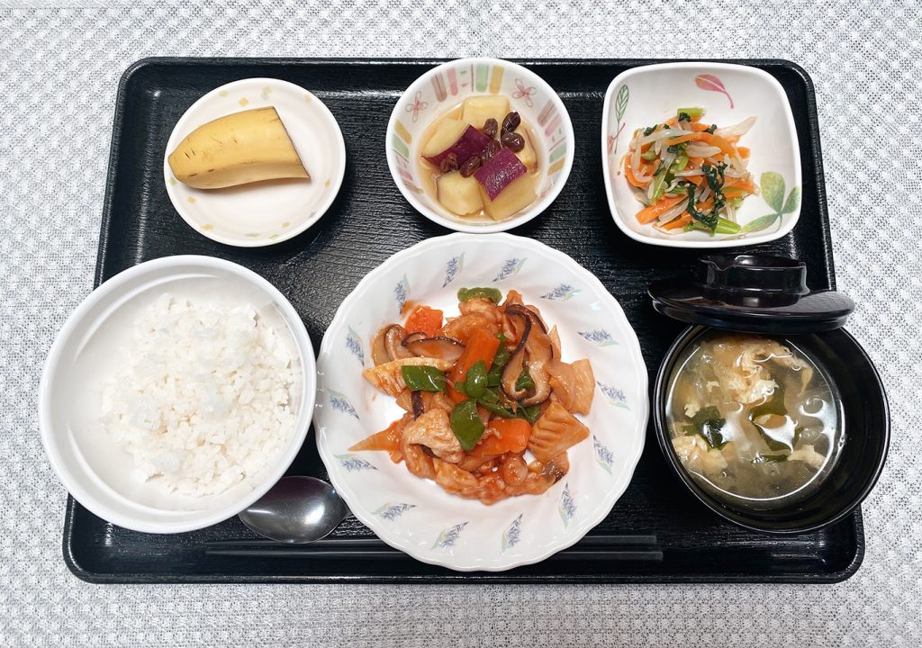 4月19日水曜日　きょうのお昼ごはんは、酢鶏・ナムル・さつまいものオレンジ煮・スープ・くだものでした。