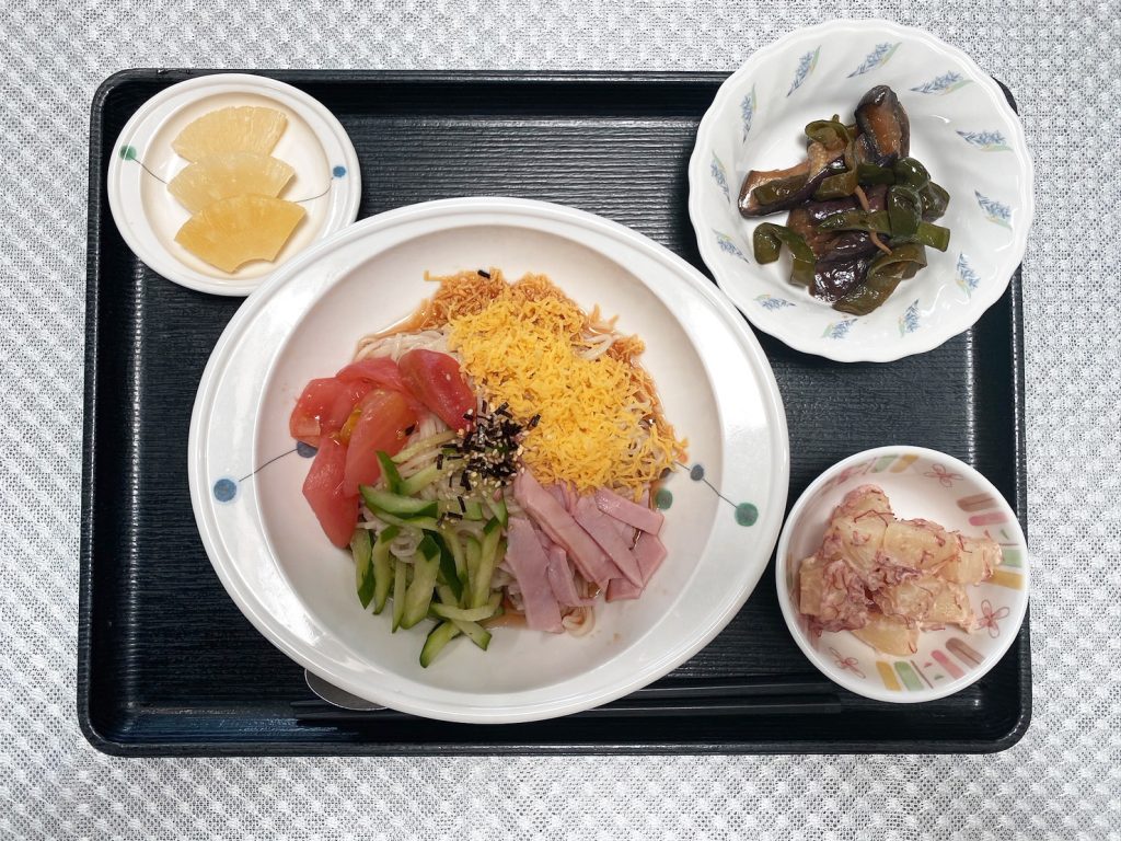 8月14日月曜日　きょうのお昼ごはんは、冷やし中華・なすとピーマンの油炒め・コンビーフポテト・くだものでした。