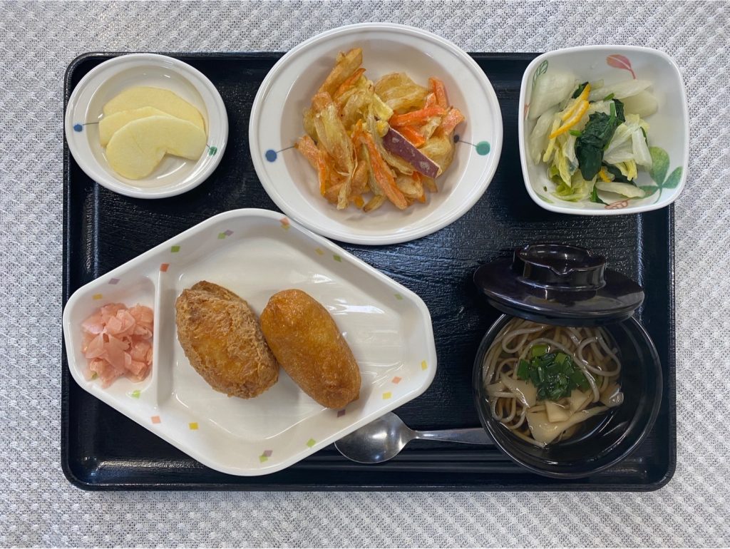 12月29日金曜日　きょうのお昼ごはんは、おそば・いなり寿司・野菜のかき揚げ・ゆず浸し・果物でした。
