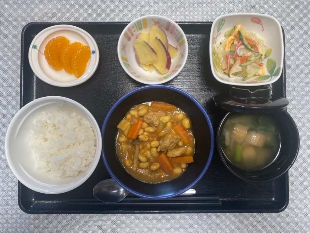 3月27日水曜日　きょうのお昼ごはんは、鶏肉と大豆のカレー煮・サラダ・さつまいものレモン蒸し・みそ汁・果物でした。