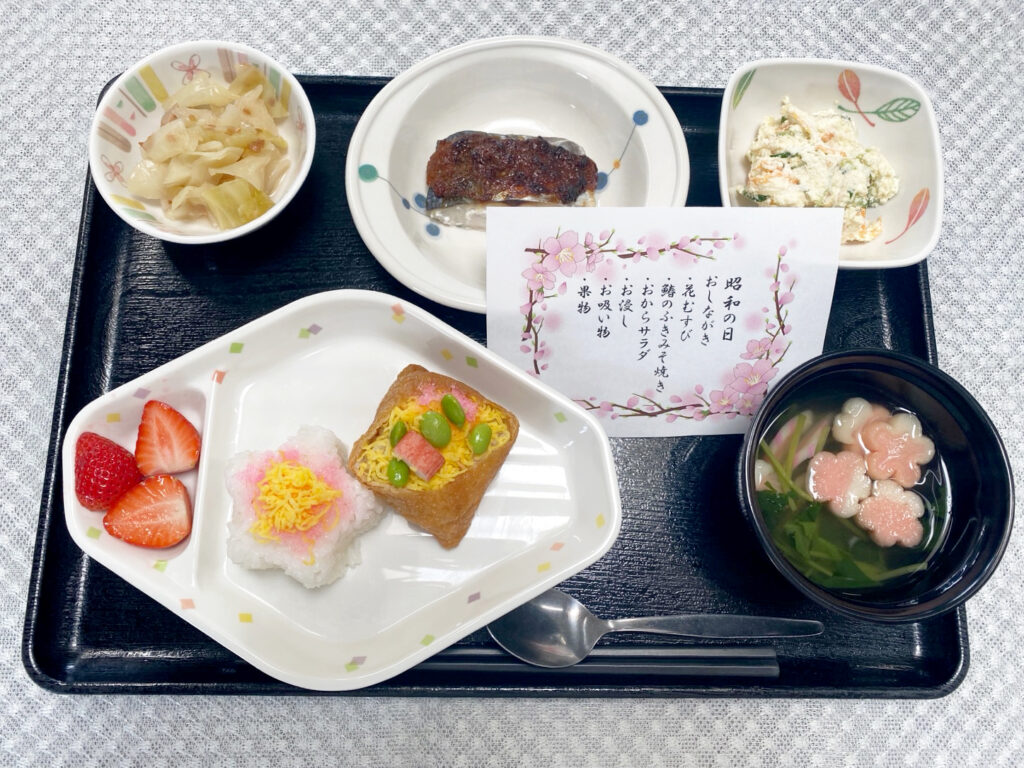 4月29日月曜日・昭和の日　きょうのお昼ごはんは、花むすび・鰆のふきみそ焼き・おからサラダ・お浸し・お吸い物・くだものでした。